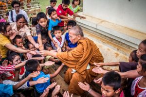 Monk with children, representing charity.