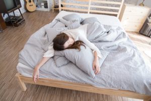 Woman laying on bed to represent Coronavirus Lazies